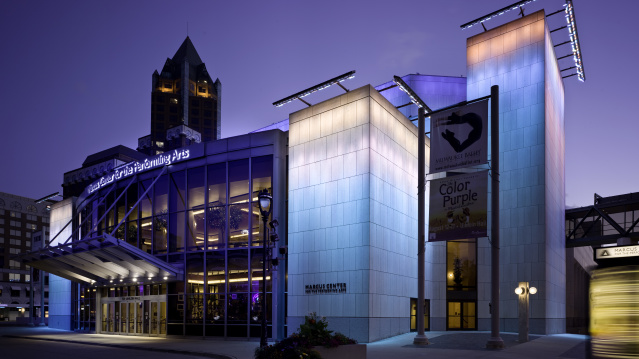 Exterior of the Marcus Performing Arts Center, glowing blue, orange and pink in the evening.