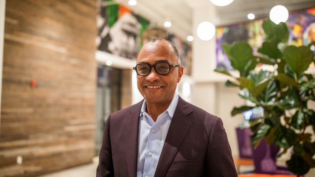 Greg Wesley stands in a modern lobby