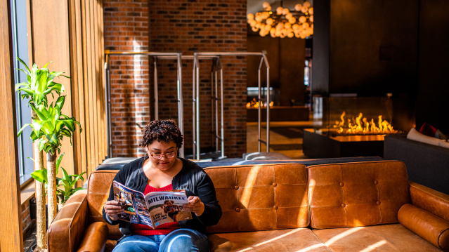 visitor reading the Official Visitors Guide in the lobby of the Journeyman Kimpton Hotel