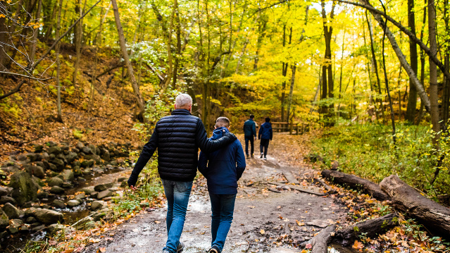 family walking on trail with fall colors surrounding