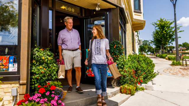 couple exiting shop with bags