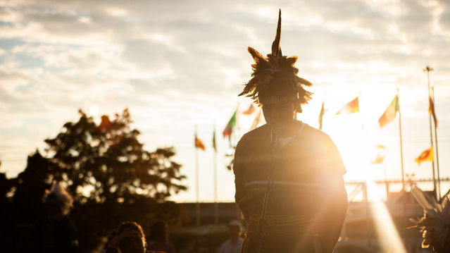 individual speaking into microphone with sunset behind