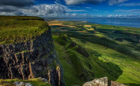 Top of Binevenagh over looking green farmland with Donegal in the distance