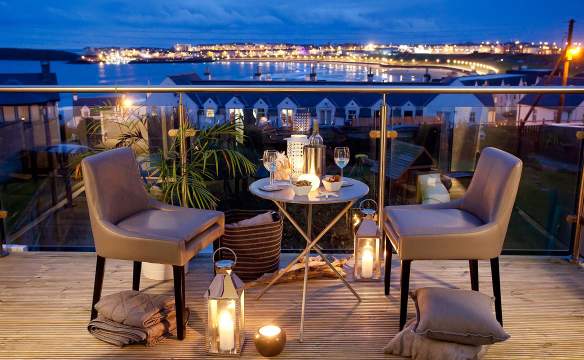 beautiful night time view from the Blackrock House B&B. Candle lit table and two chairs for an evening drink