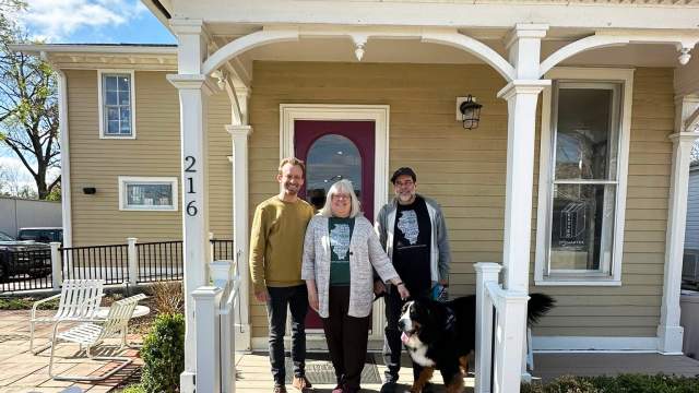 Roxanne and Chuck Osborne, owners of Harvey's Tales in Geneva, Illinois, with son outside the shop