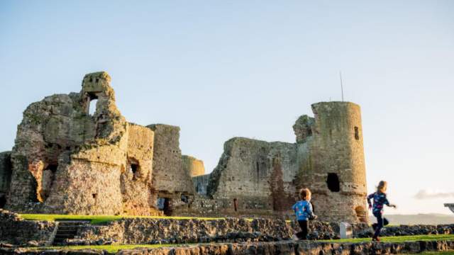 Children playing with Rhuddlan Castle in the background