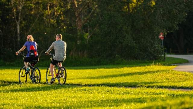 Two visitors ride their bikes through one of Parkland Florida's many beautiful parks