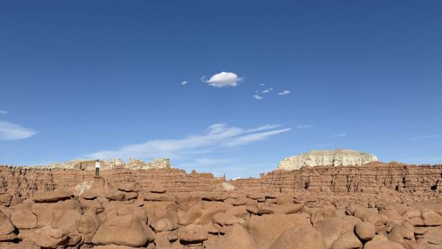 Man standing on a rock formation in Goblin Valley State Park