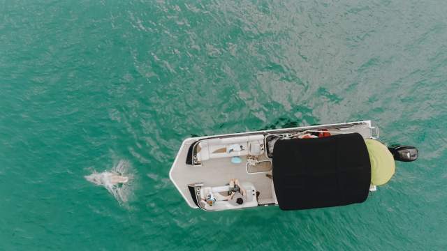 Aerial view of a person diving into the water from a boat