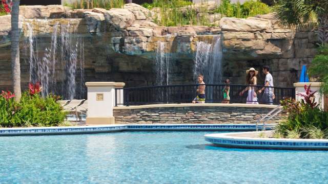 Family walking along grotto pool bridge at Hyatt Regency Orlando
