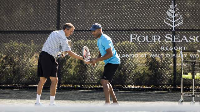 Four Seasons Resort Orlando at Walt Disney World® Resort teaching tennis to adult