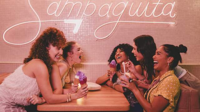 A group of ladies sitting at a booth, laughing and eating ice cream at Sampaguita Ice Cream