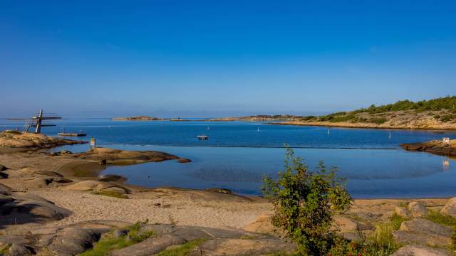Foten badeplass med stupetårn, stille sjø og solen skinner