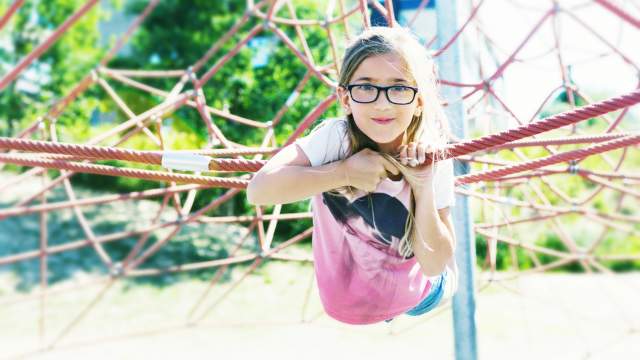 Jente som ligger i ett klatrenett