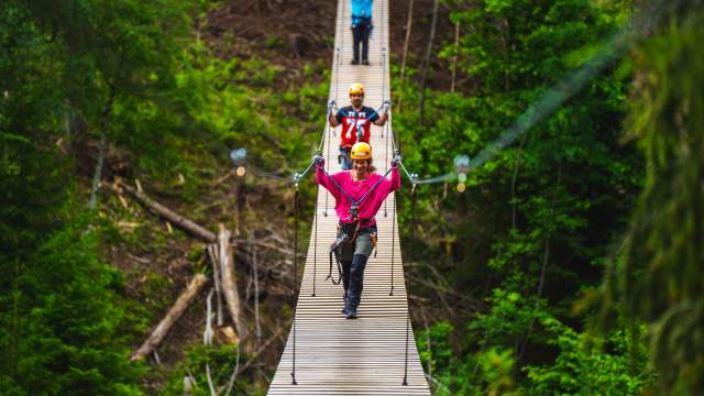 Tre personer på hengebroen i Via Ferrata Haldenkanalen