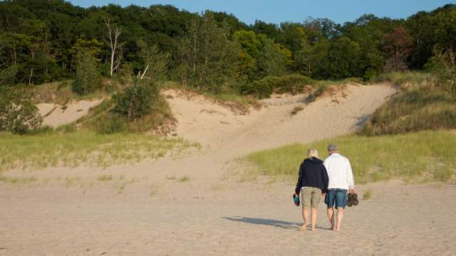 A barefoot couple walking in the dunes