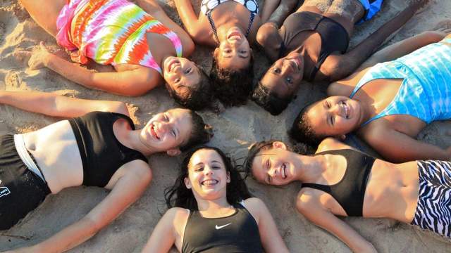 Smiling girls laying in sand