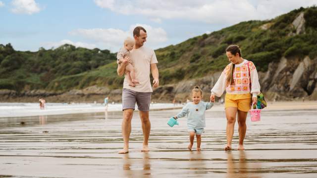 Family on Caswell beach Gower sandcastles