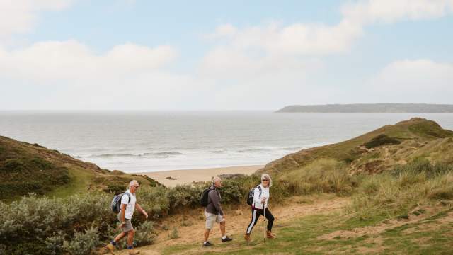 people walking across three cliffs Swansea Gower
