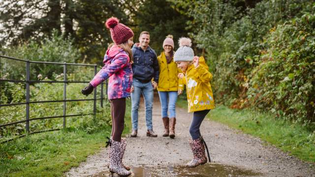 Family enjoying jumping in muddy puddles Penllergare