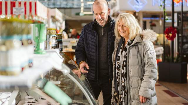 Over 50 couple walking through Swansea Market
