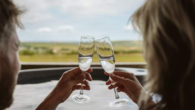 A couple having champagne in a hot tub