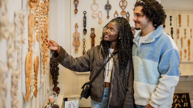 A couple looking at Welsh lovespoons in Lovespoon Gallery, Mumbles.