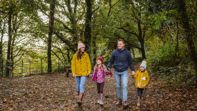 A family walking through penllergare valley woods
