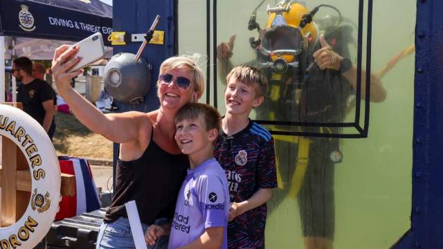 A family stood in front of a dive tank at an Airshow