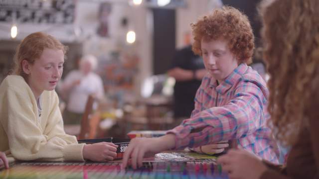 A family playing board games in common meeple, swansea