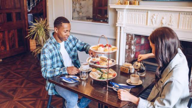 A man and woman enjoying a table full of afternoon tea at Parc le Breos