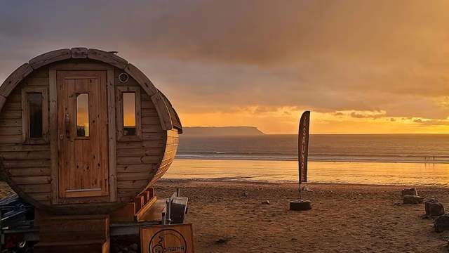 Small round wooden sauna on the beach