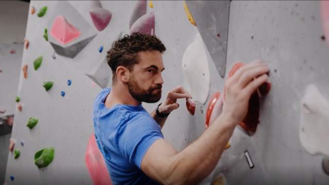 Man climbing a rock wall at the Climbing Hanger