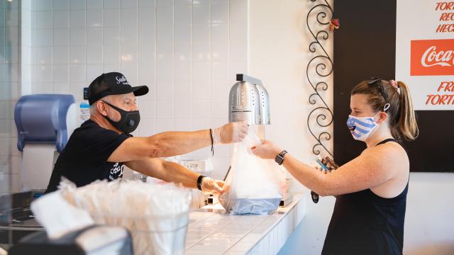 Man Handing Woman A Bag Of Food At Santo Taco in Salt Lake