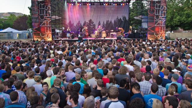 Large crowd of people in front of the stage. It is lit with colored lights and banners on each side that say Twilight Concert Series