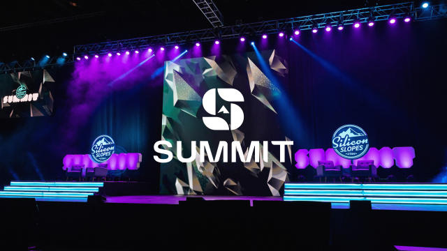 Stage setup with purple and blue lights, logos that say Silicon Slopes and a Summit Logo overlay