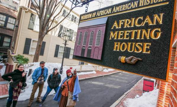 4 people looking at a sign that reads "Museum of African American History; African Meeting House."