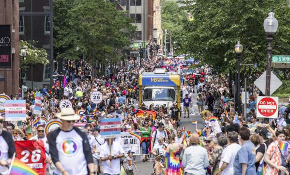 people walking down the street in celebration of the Pride Parde. featuring the mobile VIC.