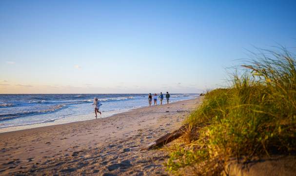 A family walks along the undeveloped beach on Little St. Simons Island, GA