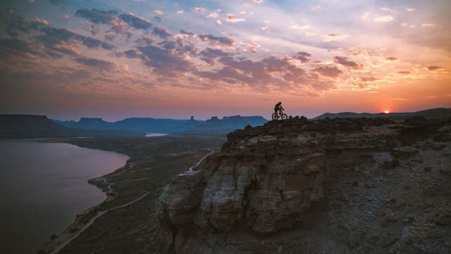 Cyclist riding along a dirt trail with views of Flaming Gorge in Sweetwater County, Wyoming.