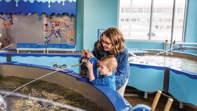 Mom and son playing in the water room at Impression 5