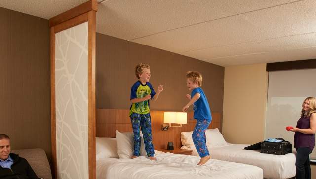 Kids jumping on hotel bed