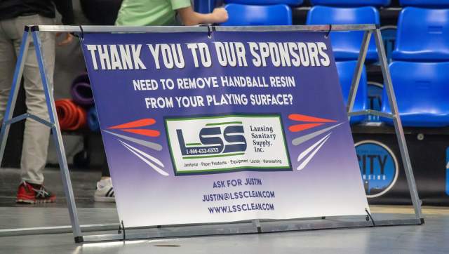 A sign reads "thank you to our sponsors" and promotes Lansing Sanitary Supply's cleaning services.