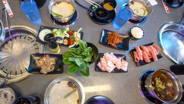Table full of meats and veggies at the KPOT Korean BBQ & Hot Pot restaurant