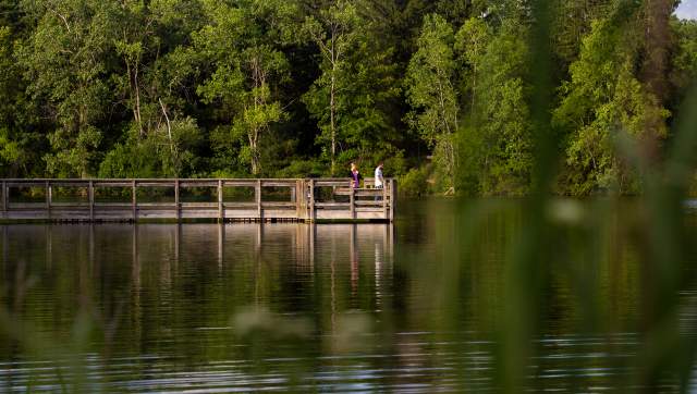 The fishing pier at Crego Park with people fishing off of it.