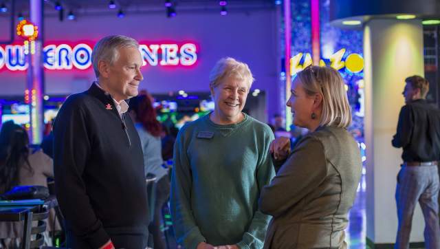 Three people standing together and chatting