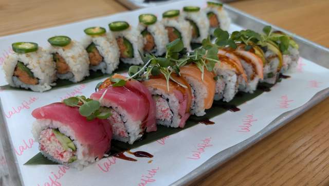 White plate with two rolls of colorful sushi