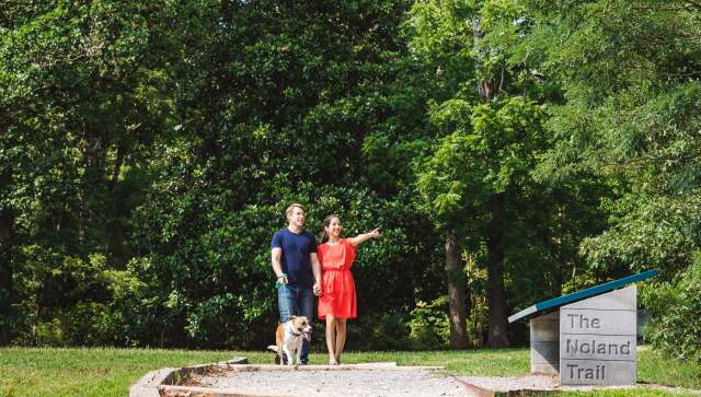 Couple walking dog on a trail