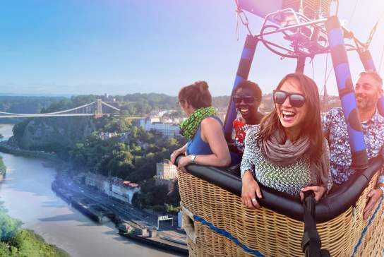 A group of people in a balloon basket flying near the Clifton Suspension Bridge in West Bristol - credit Paul Box