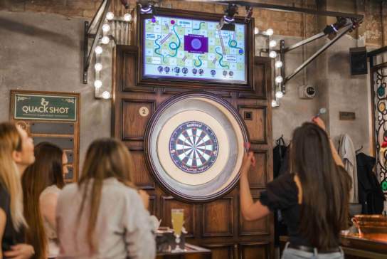 Group of people playing darts at Flight Club.